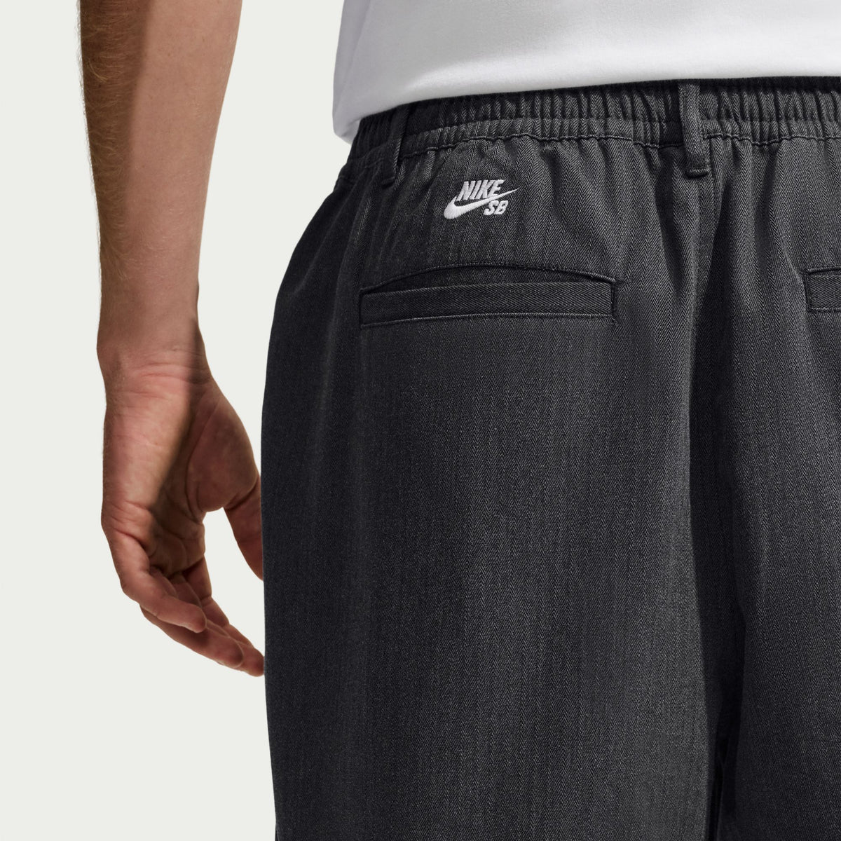 Nike SB Bagel Skate Shorts in Black / White, close-up of the rear pocket and white Nike SB embroidery.